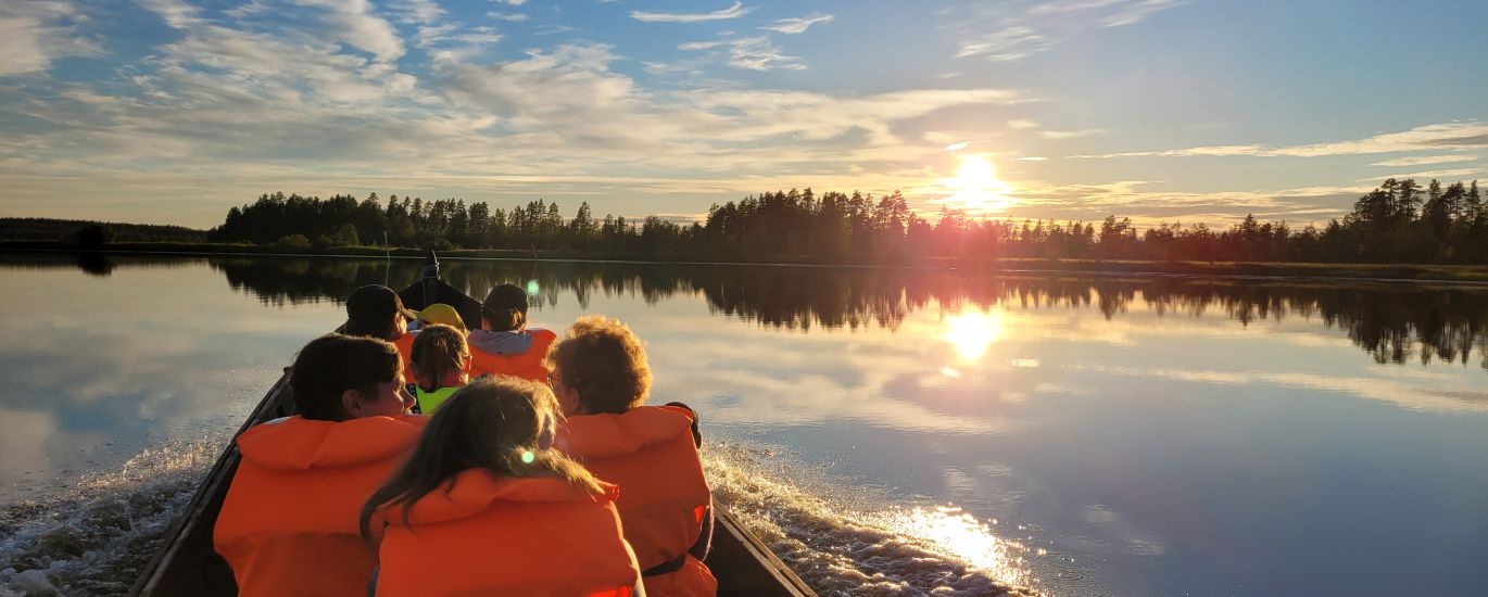 Jokiveneretkeläiset ihailemassa auringonlaskua Nuorajärvellä.